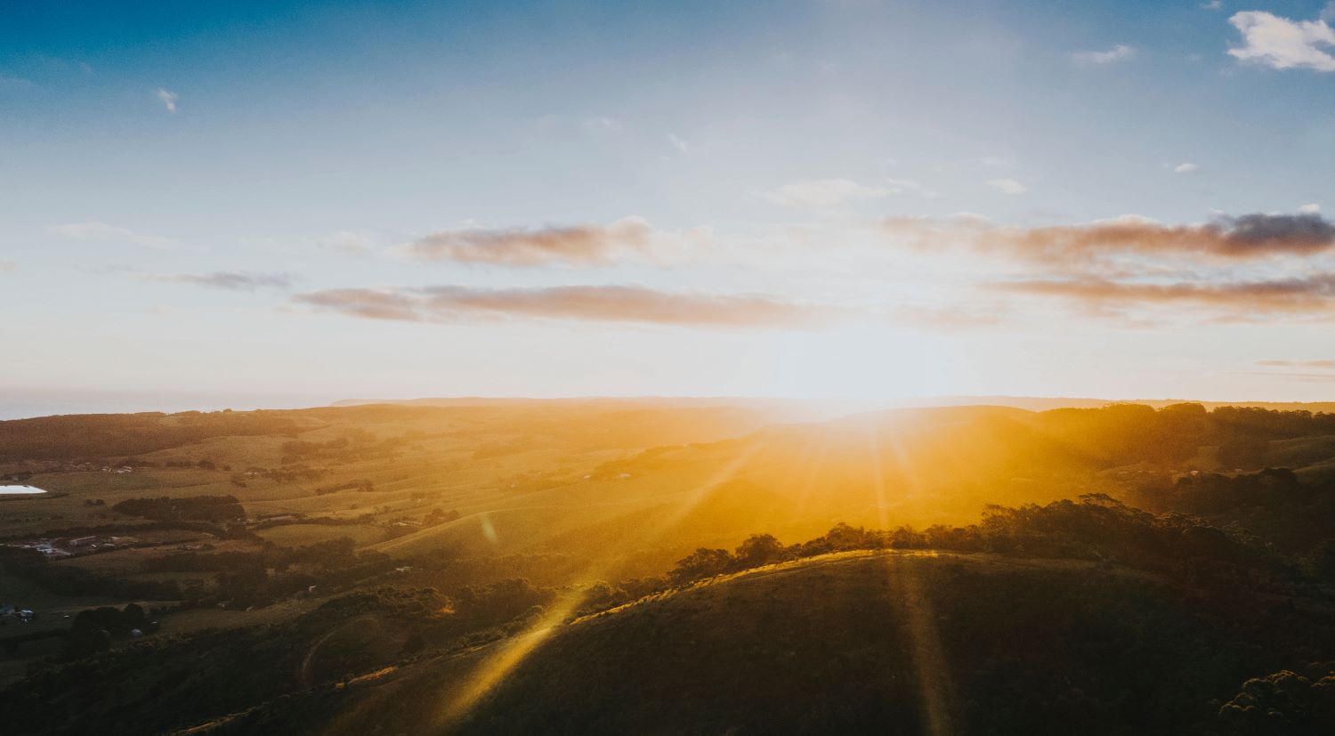 Coucher de soleil sur un champ lumineux, symbole d’éveil à l’abondance intérieure.